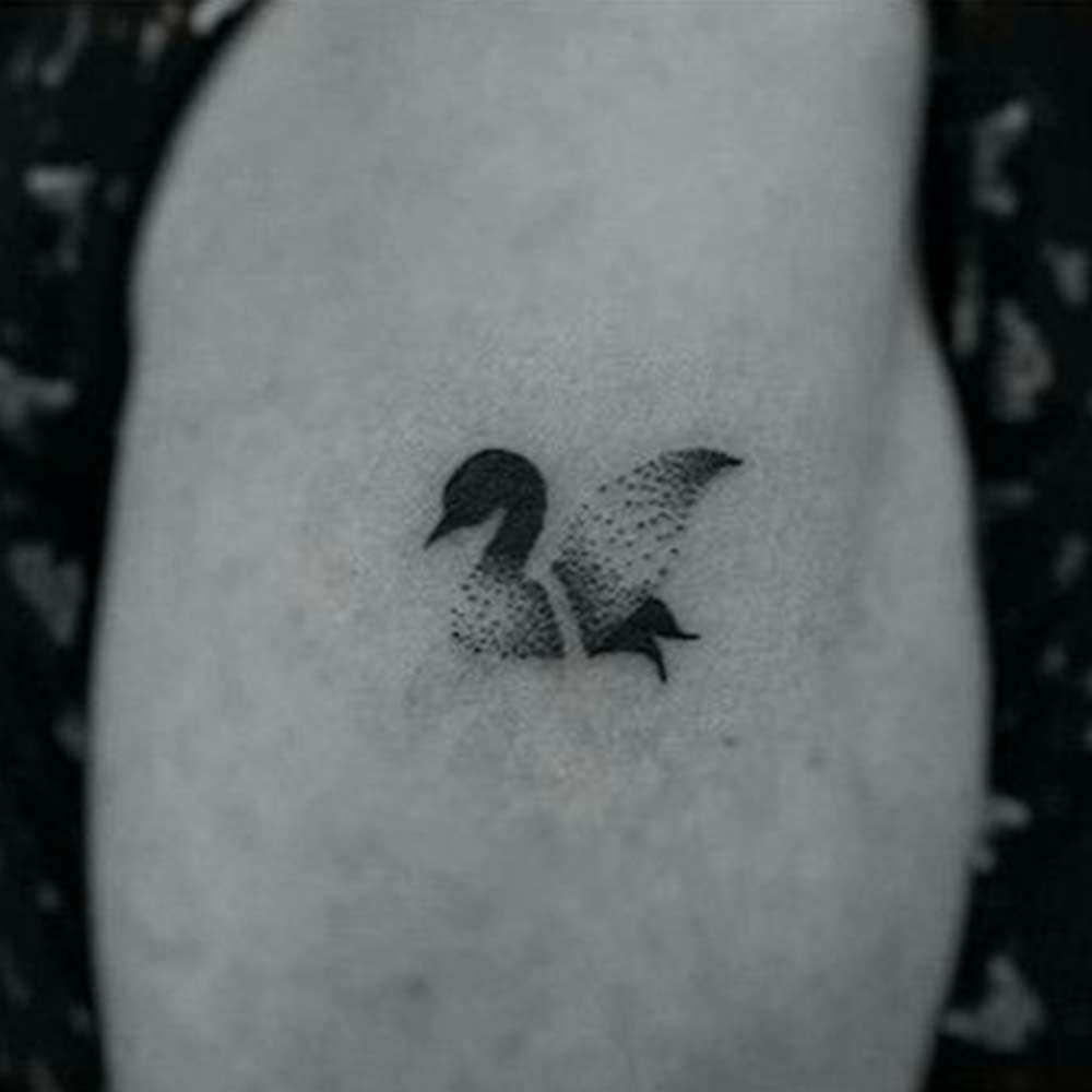 abstract duck tattoo in black ink on knee